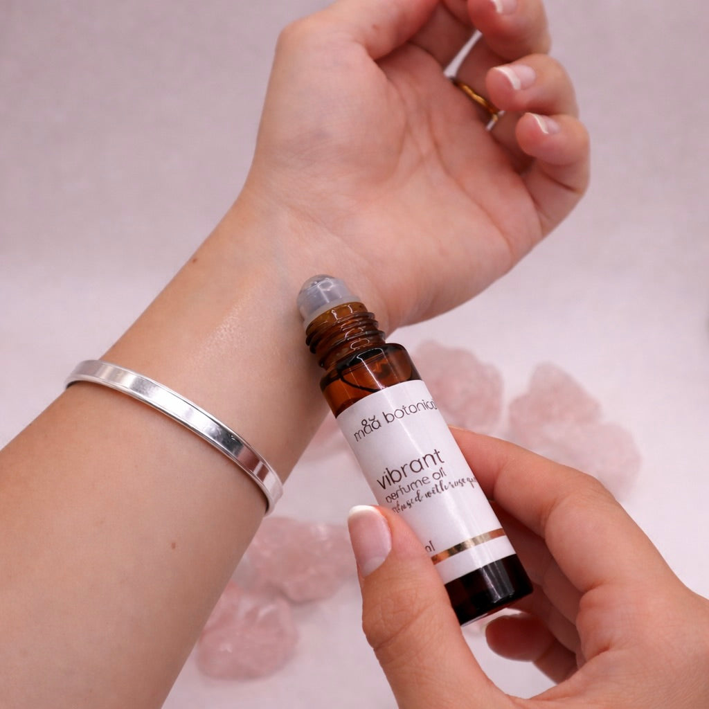 Hand holding maa botanicals vibrant roll on perfume oil