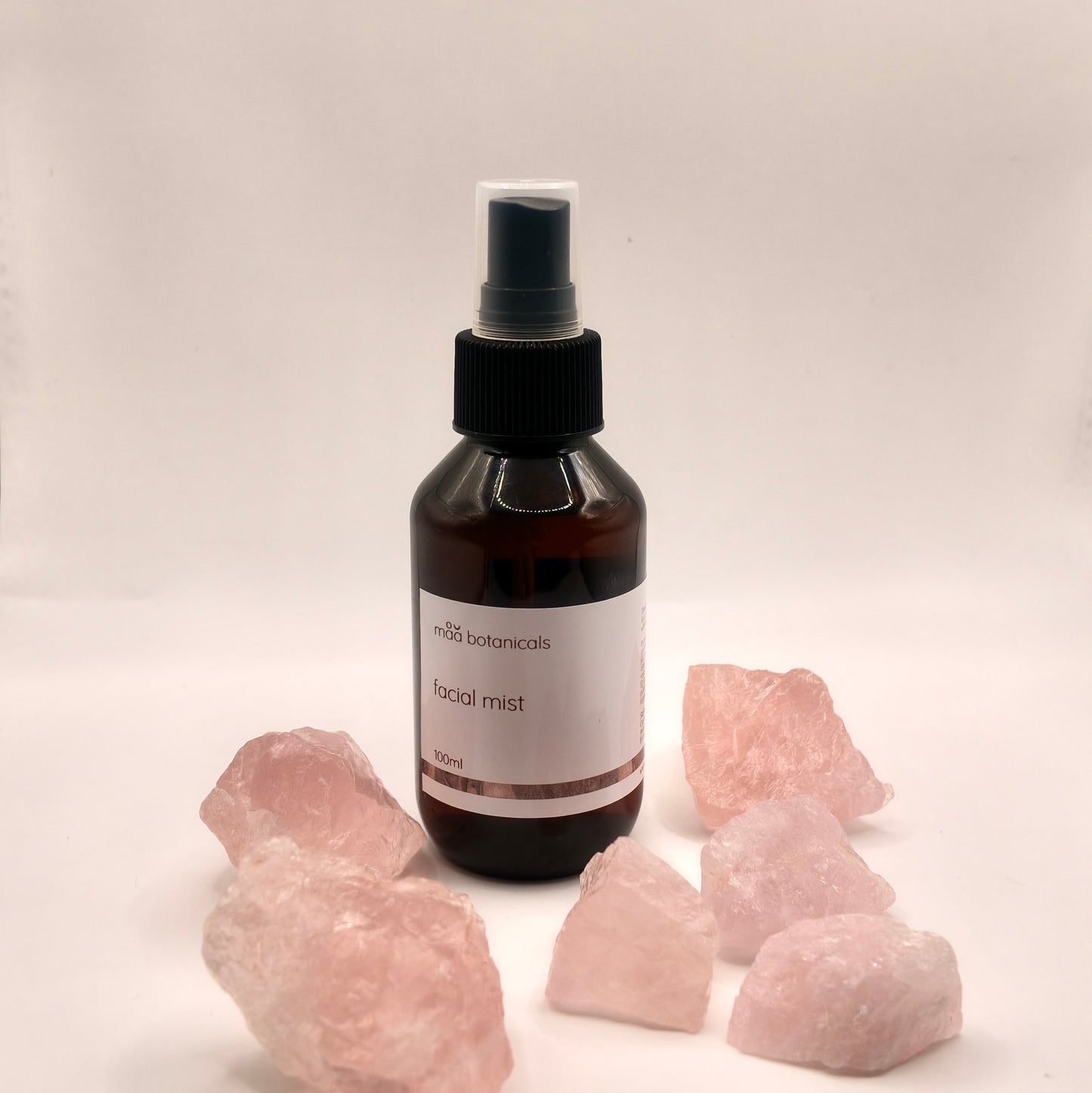 maa botanicals facial mist in a 100ml amber bottle with mist spray surrounded by rose quartz crystal