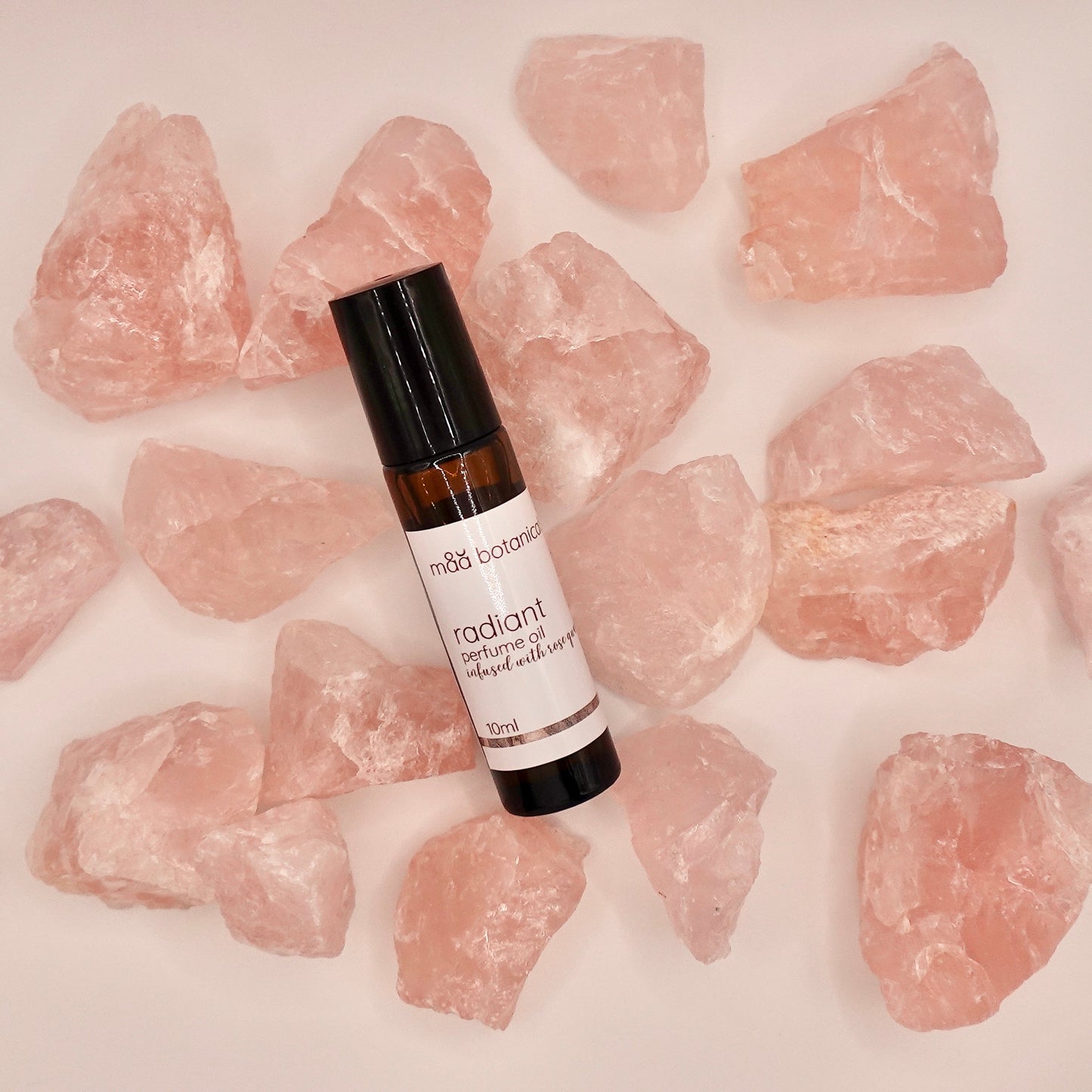 radiant perfume oil by maa botanicals surrounded by rose quartz crystals 
