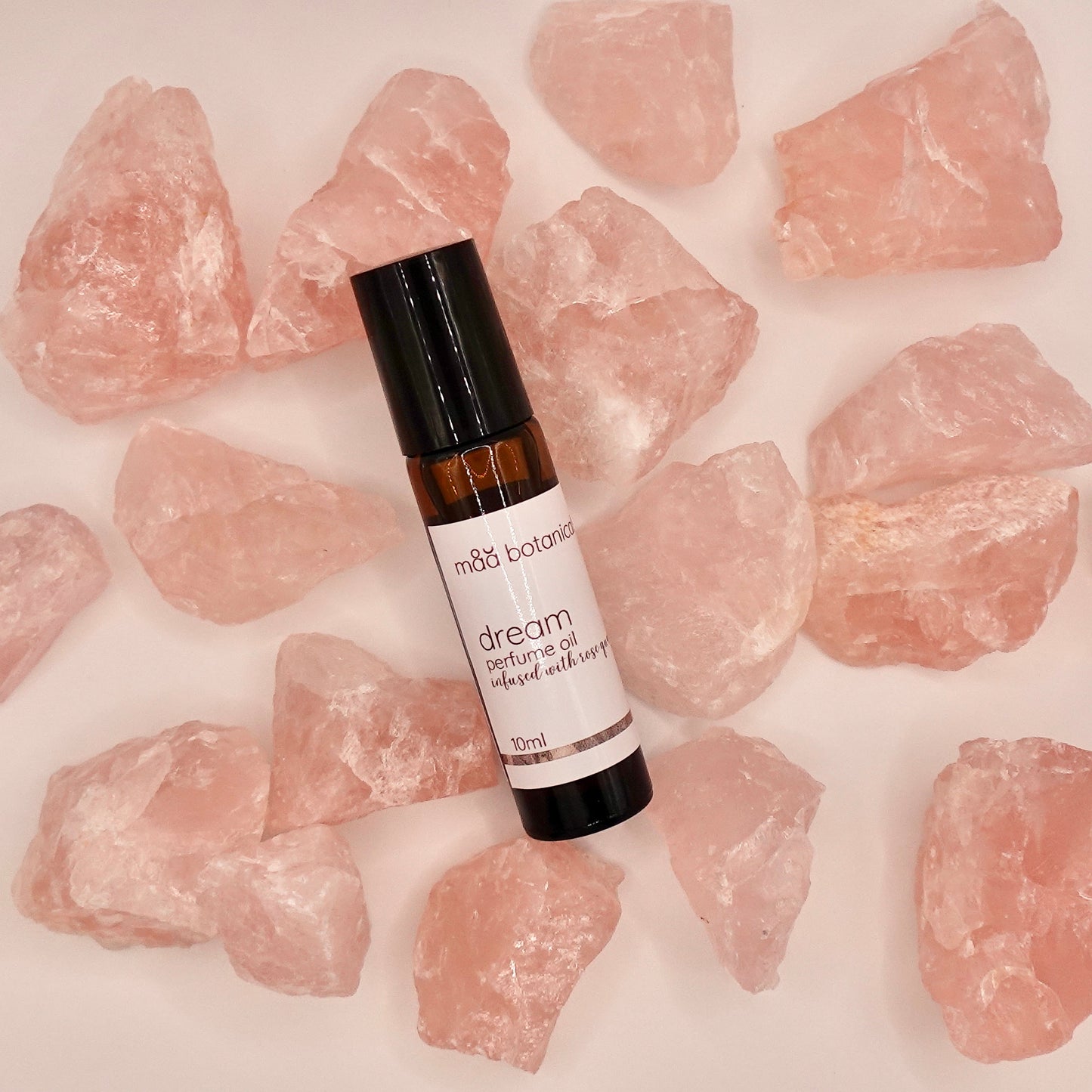 maa botanicals dream perfume oil surrounded by rose quartz crystals