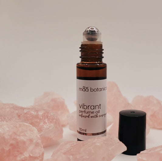 Roll-on bottle of mäa botanicals vibrant perfume oil with rose quartz crystals 