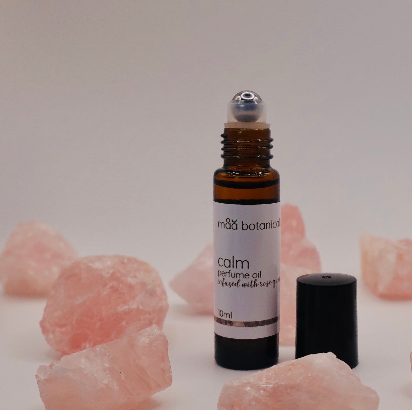 maa botanicals calm roll-on perfume oil with rose quartz crystals.