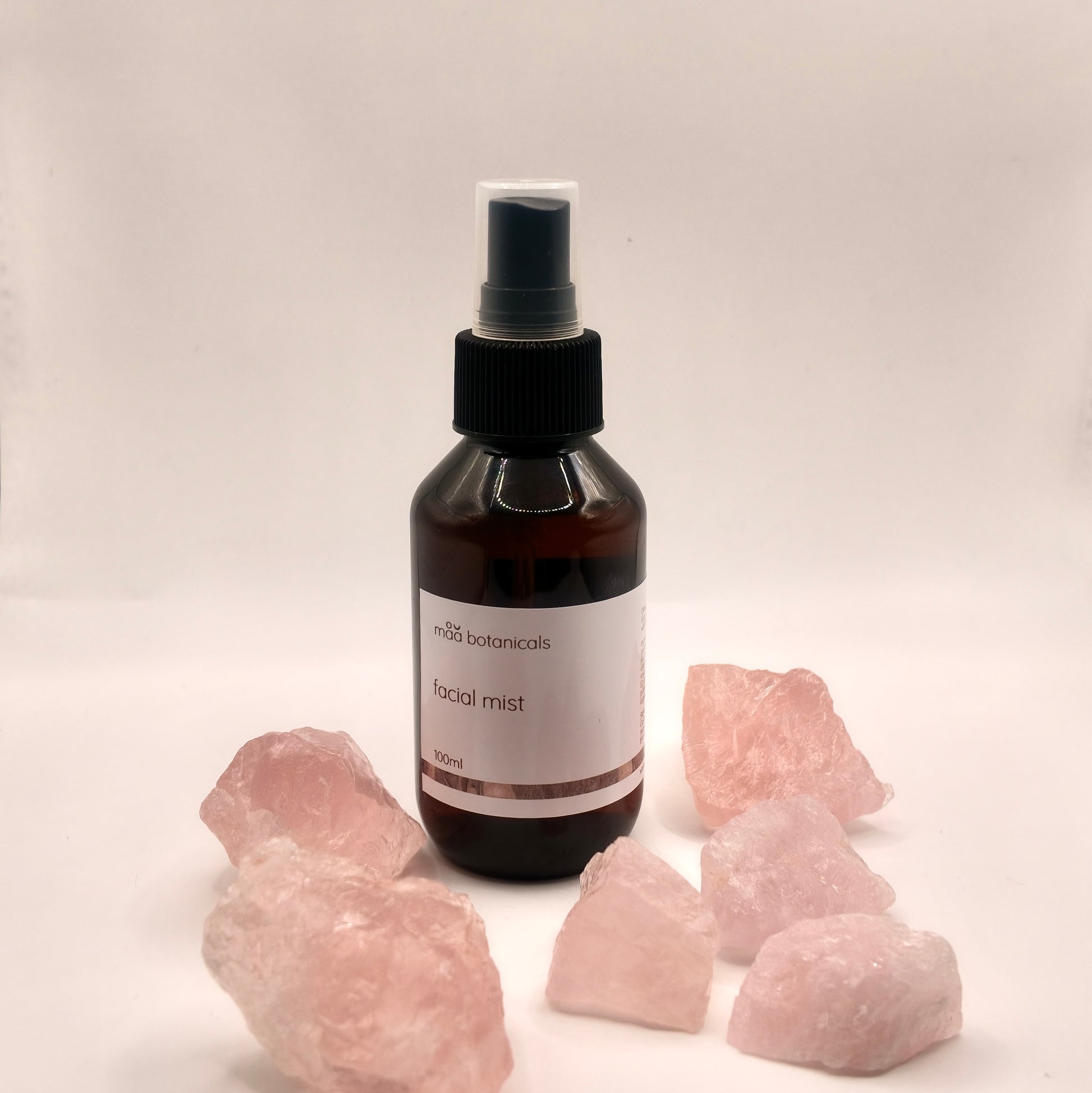 maa botanicals facial mist in a 100ml amber bottle with mist spray surrounded by rose quartz crystal