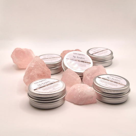 lip balms in a 15g aluminium tin surrounded by rose quartz crystal