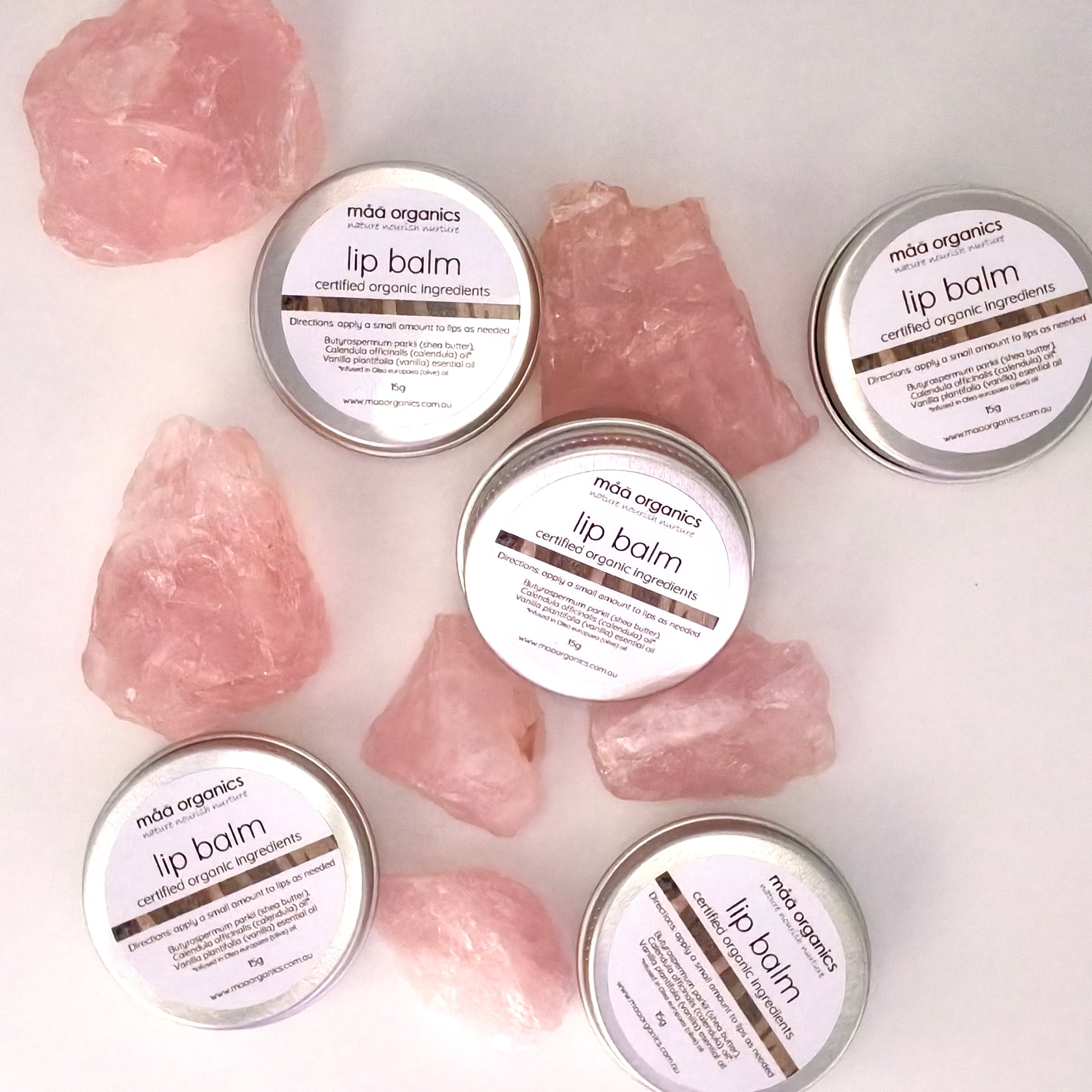 lip balms in a 15g aluminium tin surrounded by rose quartz crystal