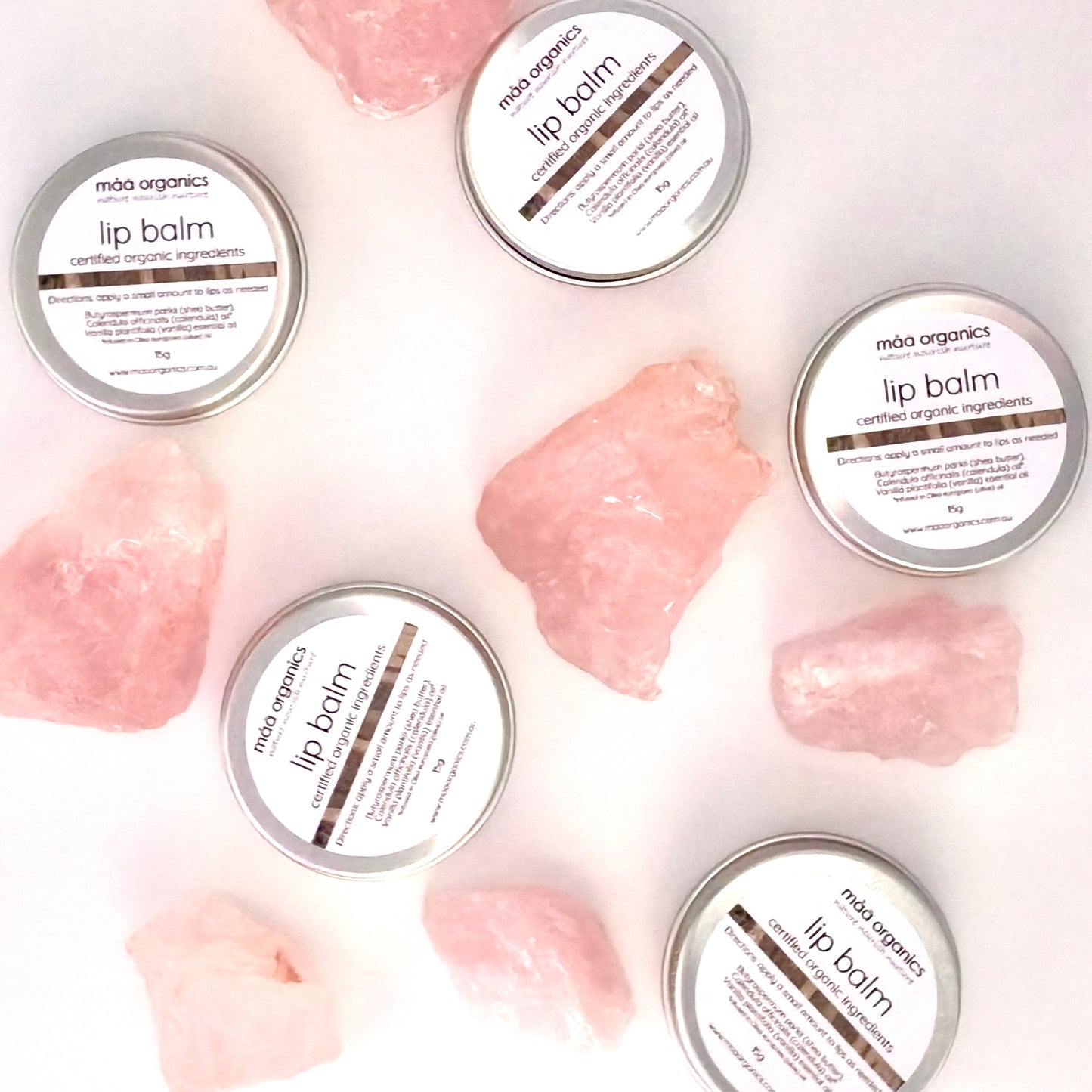 lip balms in a 15g aluminium tin surrounded by rose quartz crystal