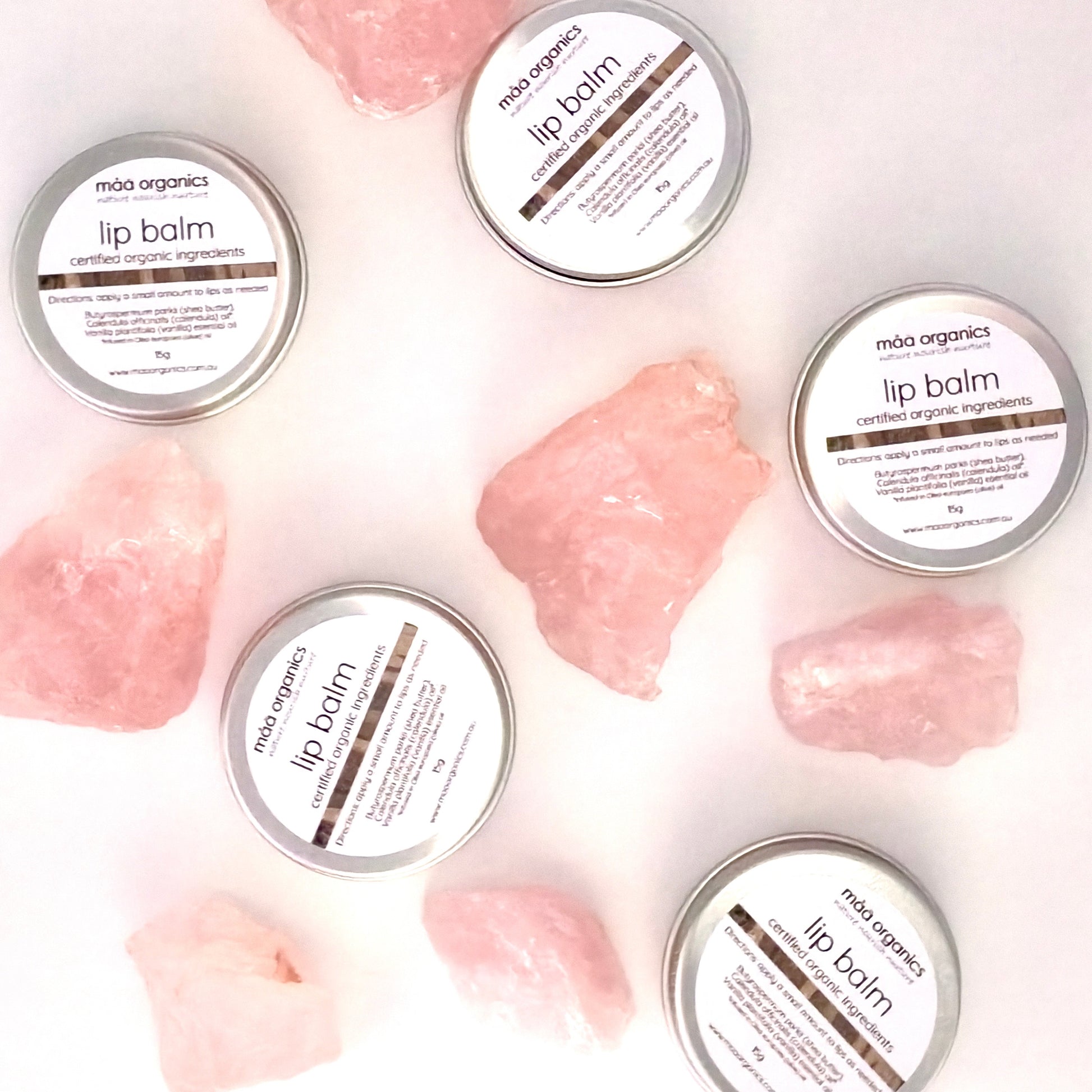 lip balms in a 15g aluminium tin surrounded by rose quartz crystal