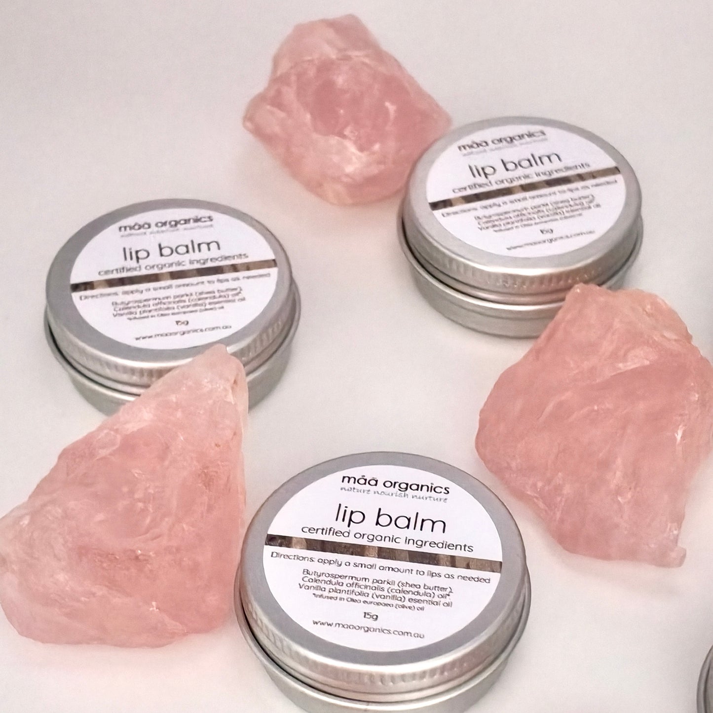 lip balms in a 15g aluminium tin surrounded by rose quartz crystal