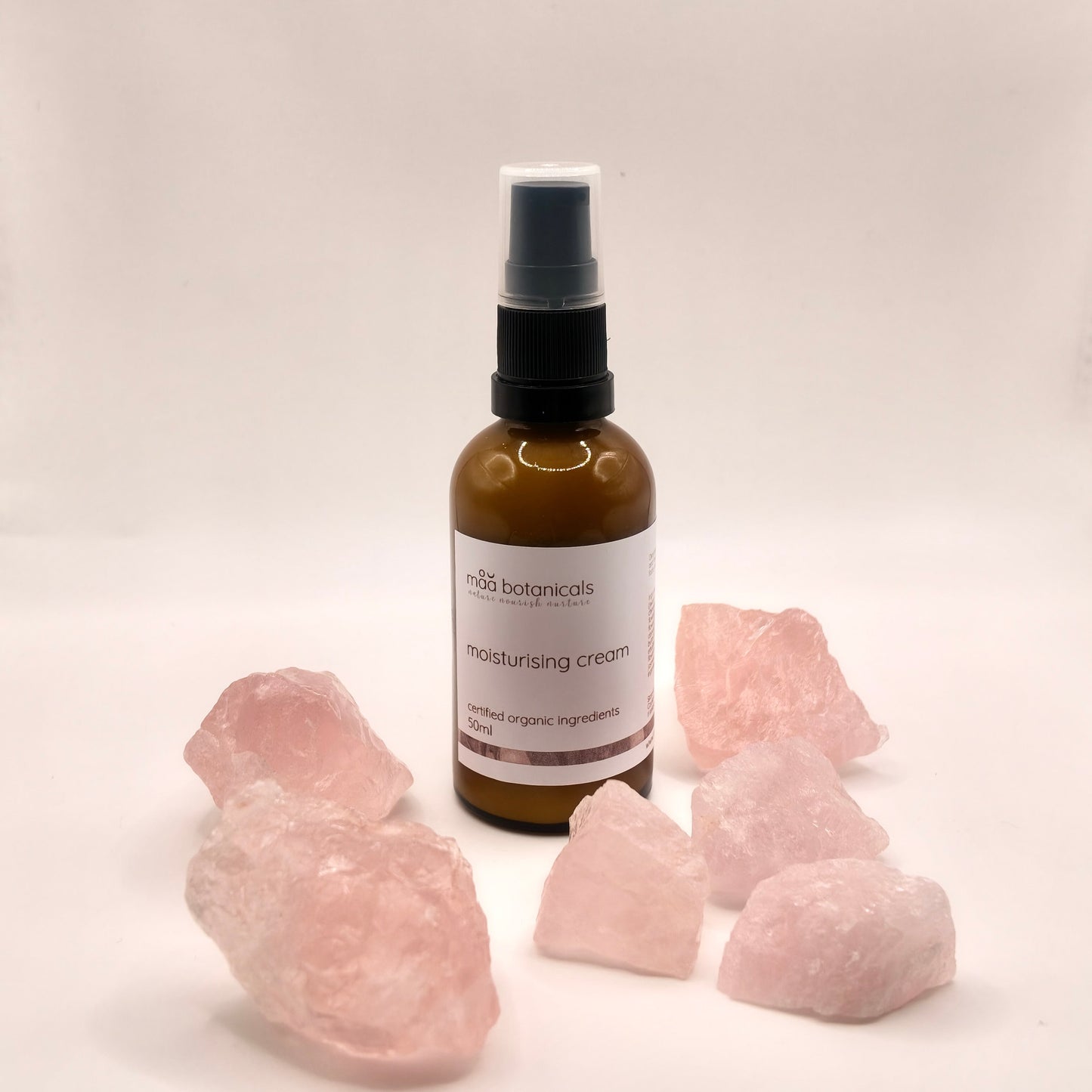 maa botanicals moisturising cream in a 50ml amber bottle surrounded with rose quartz crystal