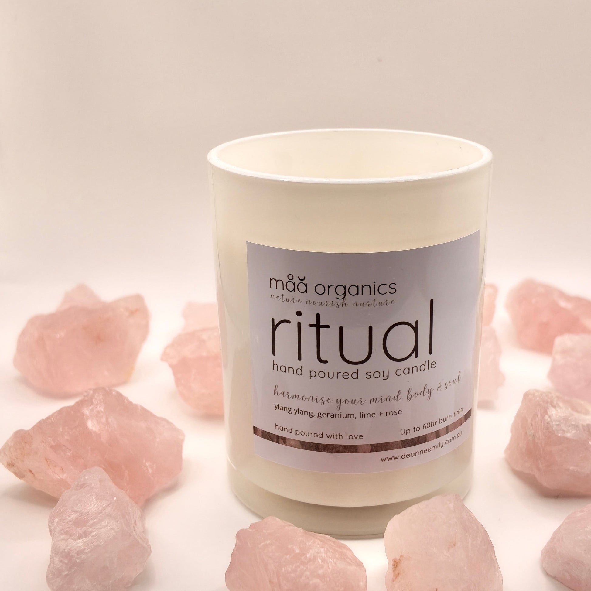 maa botanicals candle in a white opaque jar surrounded by rose quartz crystals